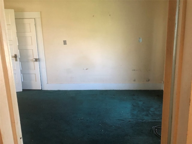 unfurnished room with dark colored carpet