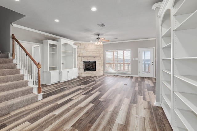 unfurnished living room with crown molding, ceiling fan, dark hardwood / wood-style floors, and a fireplace