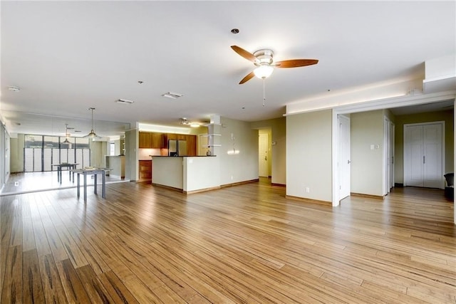 unfurnished living room with ceiling fan and light wood-type flooring