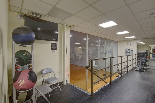 interior space with a drop ceiling and hardwood / wood-style floors