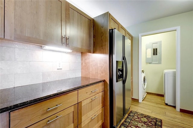 kitchen featuring light hardwood / wood-style flooring, independent washer and dryer, backsplash, stainless steel fridge with ice dispenser, and dark stone countertops