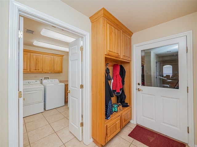 mudroom with light tile floors and independent washer and dryer