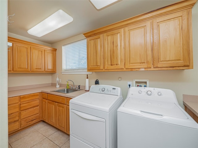 washroom featuring washer hookup, sink, light tile floors, washer and clothes dryer, and cabinets