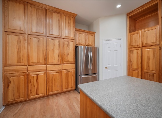 kitchen featuring stainless steel fridge and light hardwood / wood-style flooring