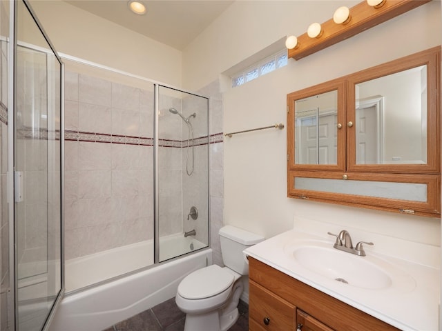 full bathroom featuring toilet, tile flooring, vanity, and bath / shower combo with glass door