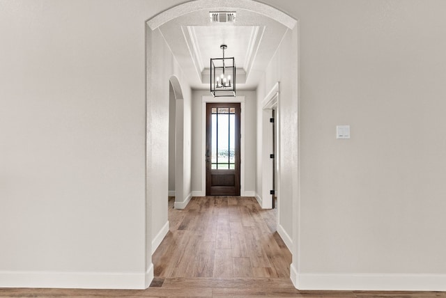 doorway featuring a chandelier, a textured ceiling, and hardwood / wood-style floors