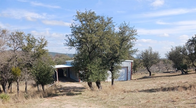 view of yard featuring a rural view and a garage