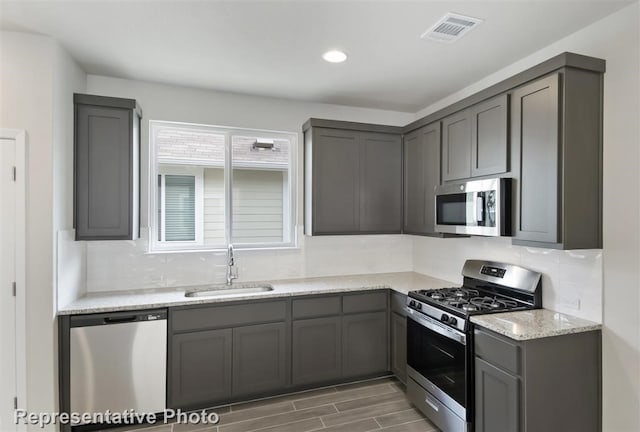 kitchen with gray cabinets, appliances with stainless steel finishes, and sink