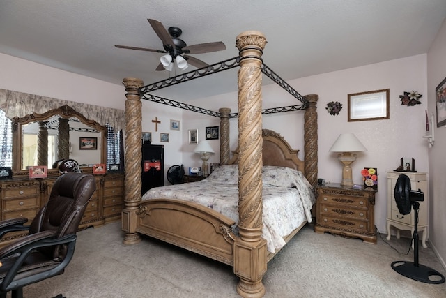 carpeted bedroom featuring ceiling fan and a textured ceiling