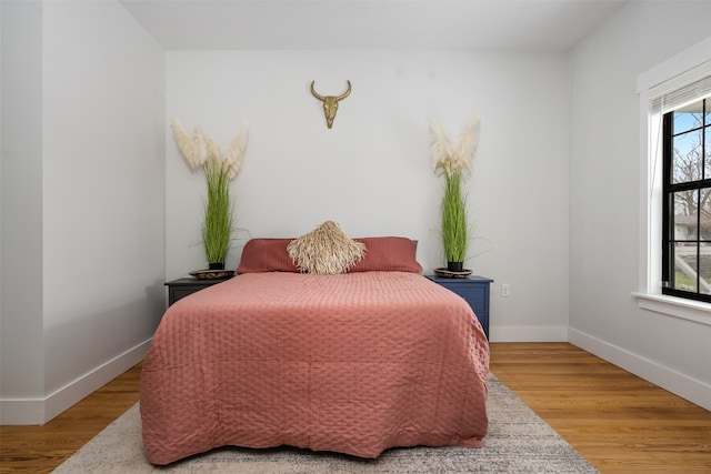 bedroom featuring multiple windows and light wood-type flooring