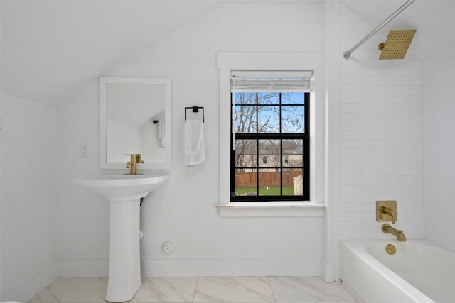 bathroom featuring tile floors, lofted ceiling, and tiled shower / bath