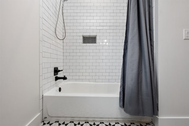 bathroom with tile floors and shower / bath combo with shower curtain