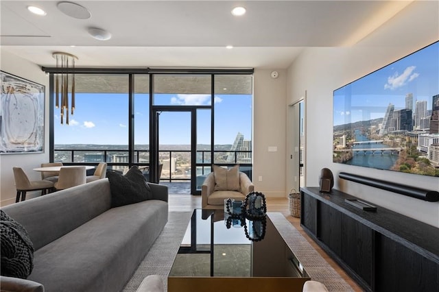 living room featuring a water view, a healthy amount of sunlight, and light wood-type flooring