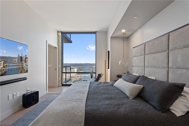 bedroom featuring floor to ceiling windows and light hardwood / wood-style floors