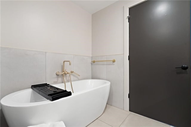 bathroom with tile walls, tile floors, and a washtub