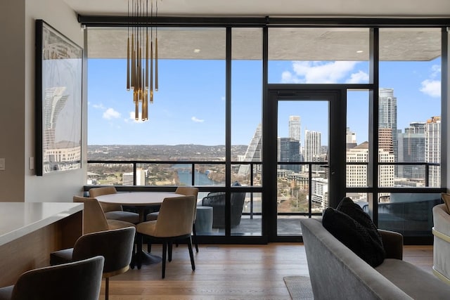 dining area with floor to ceiling windows, plenty of natural light, and light hardwood / wood-style floors