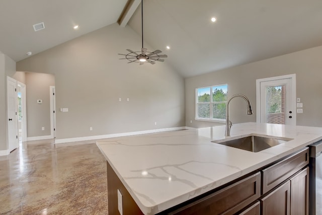 kitchen featuring light stone countertops, ceiling fan, beamed ceiling, a center island with sink, and sink