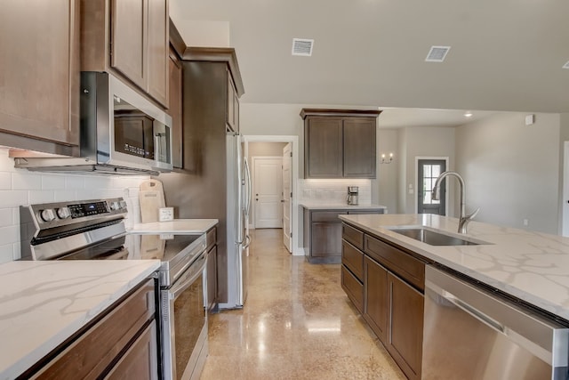 kitchen with light stone countertops, tasteful backsplash, sink, and stainless steel appliances