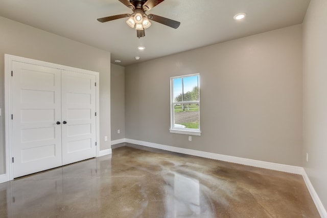 empty room featuring ceiling fan and concrete flooring