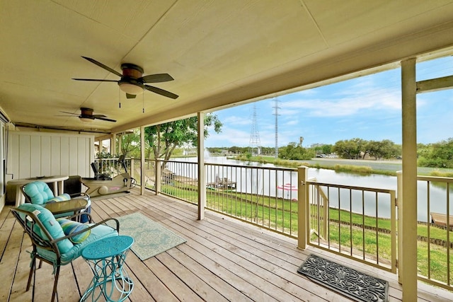 wooden terrace with a lawn, ceiling fan, and a water view