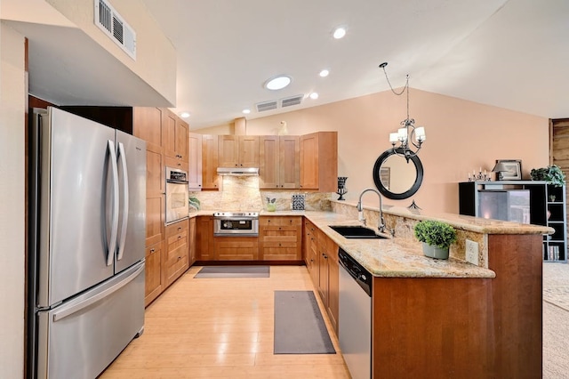 kitchen featuring kitchen peninsula, appliances with stainless steel finishes, lofted ceiling, backsplash, and sink