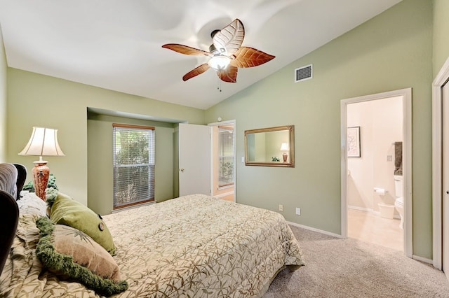 bedroom with ceiling fan, lofted ceiling, light colored carpet, and ensuite bathroom