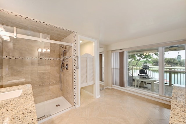 bathroom with tile flooring, an enclosed shower, and sink