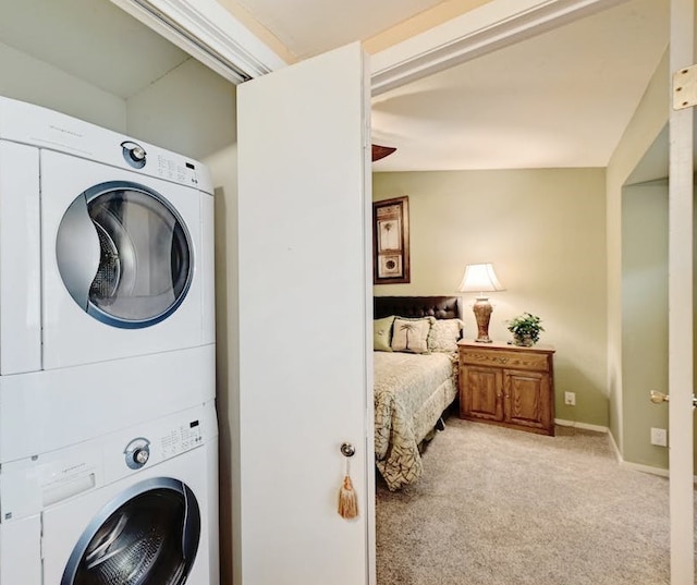 clothes washing area featuring light carpet and stacked washing maching and dryer