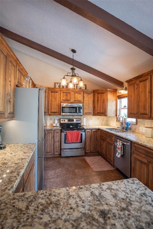 kitchen featuring a chandelier, a textured ceiling, appliances with stainless steel finishes, dark tile flooring, and sink