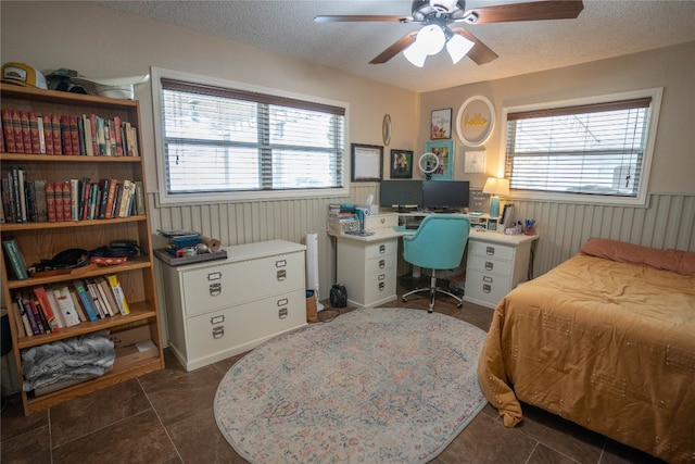 tiled bedroom featuring ceiling fan and a textured ceiling