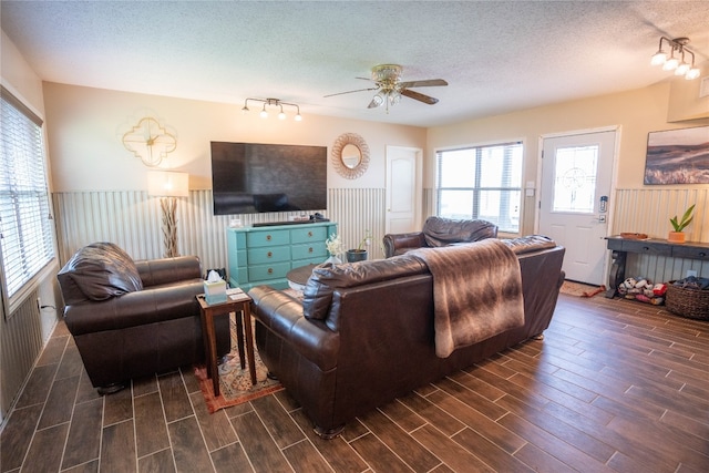 living room featuring dark hardwood / wood-style flooring, ceiling fan, a textured ceiling, and rail lighting