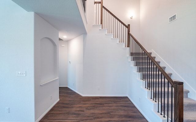 stairway with dark hardwood / wood-style flooring