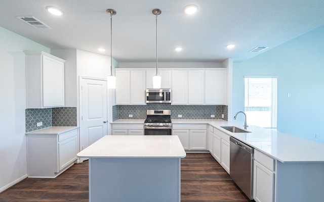 kitchen featuring appliances with stainless steel finishes, pendant lighting, sink, and dark hardwood / wood-style floors