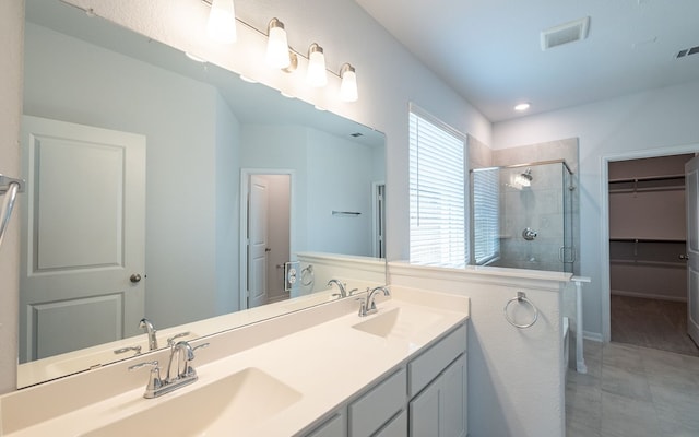 bathroom featuring oversized vanity, tile floors, double sink, and a shower with door