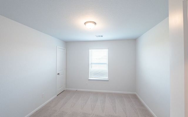 spare room featuring light colored carpet