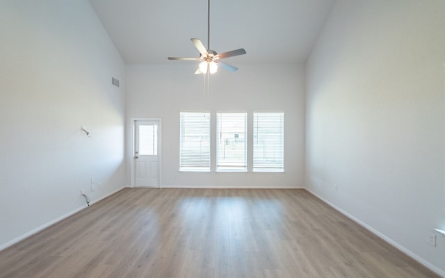 empty room featuring high vaulted ceiling, ceiling fan, and light hardwood / wood-style flooring