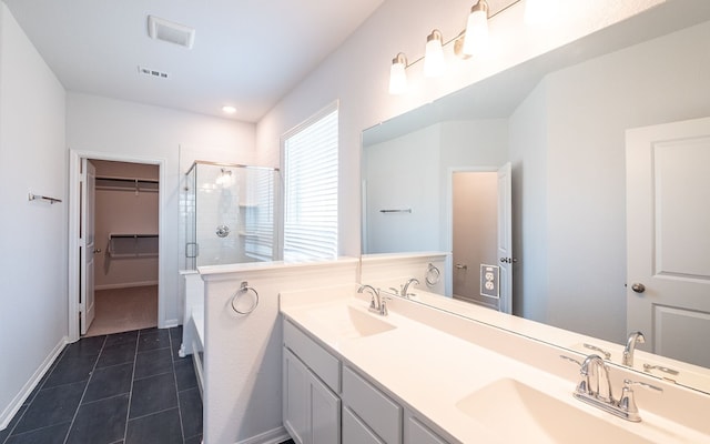 bathroom with double sink, tile flooring, oversized vanity, and a shower with door