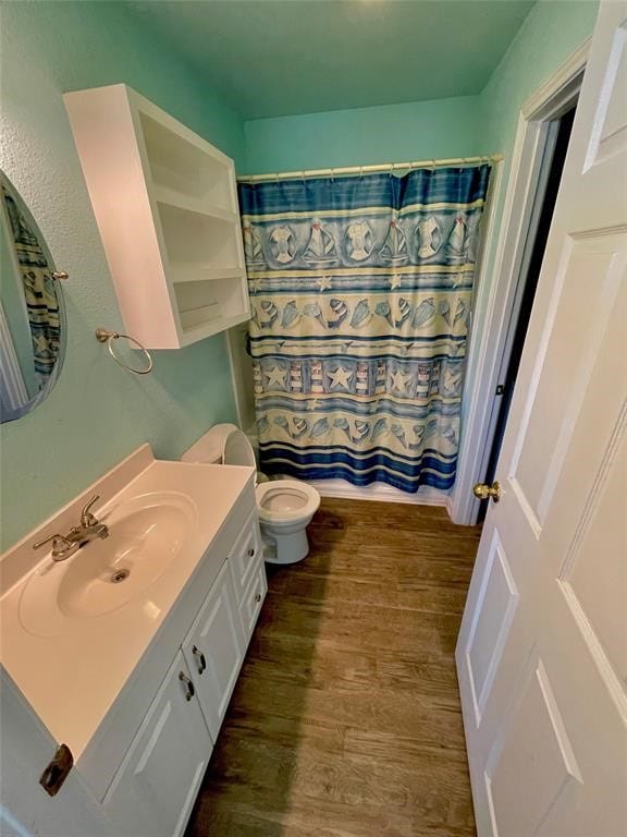 bathroom with toilet, vanity, and hardwood / wood-style flooring