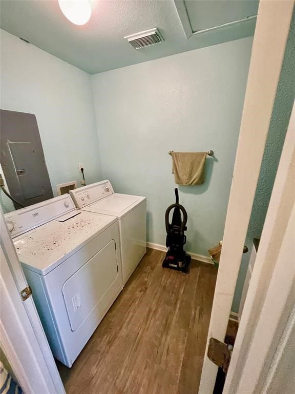 clothes washing area with independent washer and dryer and hardwood / wood-style flooring