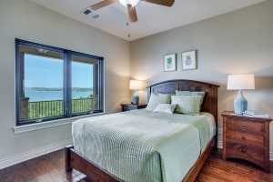 bedroom featuring a water view, dark hardwood / wood-style flooring, and ceiling fan