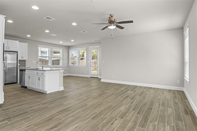 kitchen featuring light hardwood / wood-style flooring, stainless steel appliances, white cabinets, and ceiling fan