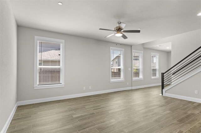 unfurnished living room with ceiling fan and light hardwood / wood-style flooring