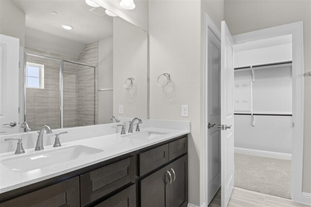 bathroom with vanity and a shower with door