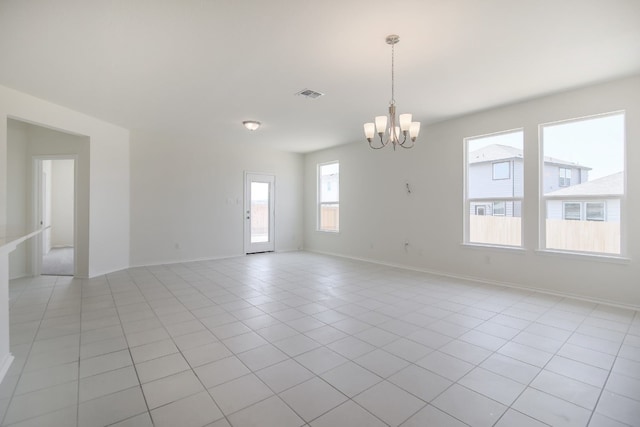 tiled empty room with a notable chandelier