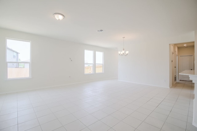 unfurnished room featuring light tile patterned floors and a notable chandelier