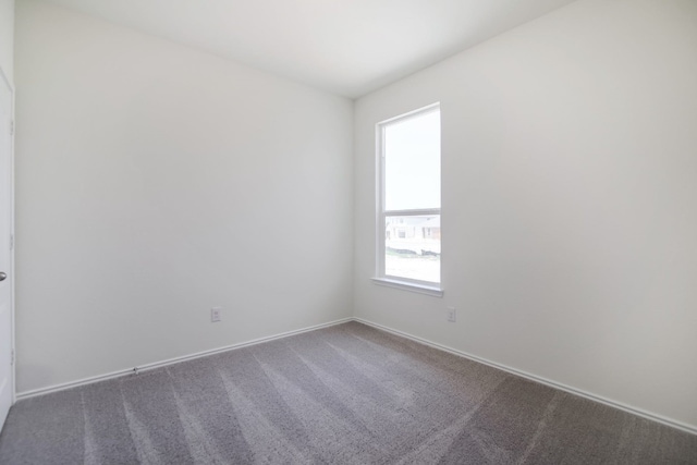 spare room featuring dark colored carpet