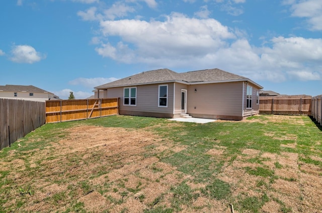 rear view of property with a yard