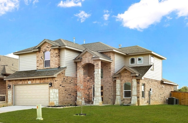 view of front facade with central AC, a front yard, and a garage