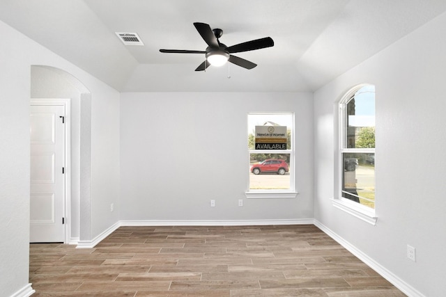 empty room with lofted ceiling, ceiling fan, and light wood-type flooring