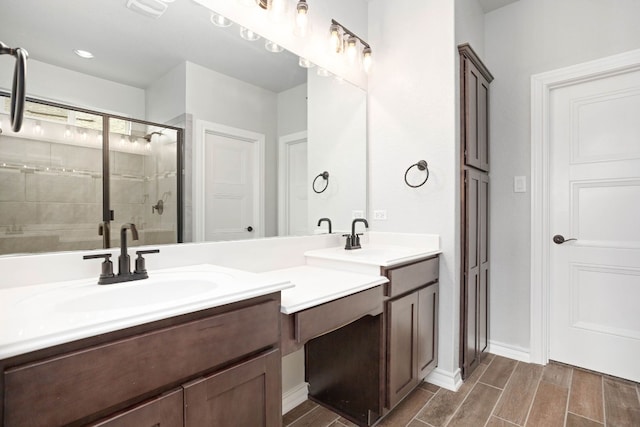 bathroom with double sink, a shower with door, and oversized vanity